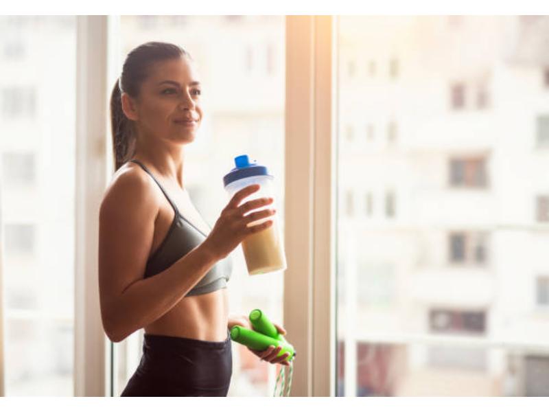 Woman drinking protein powder to help manage PCOS.